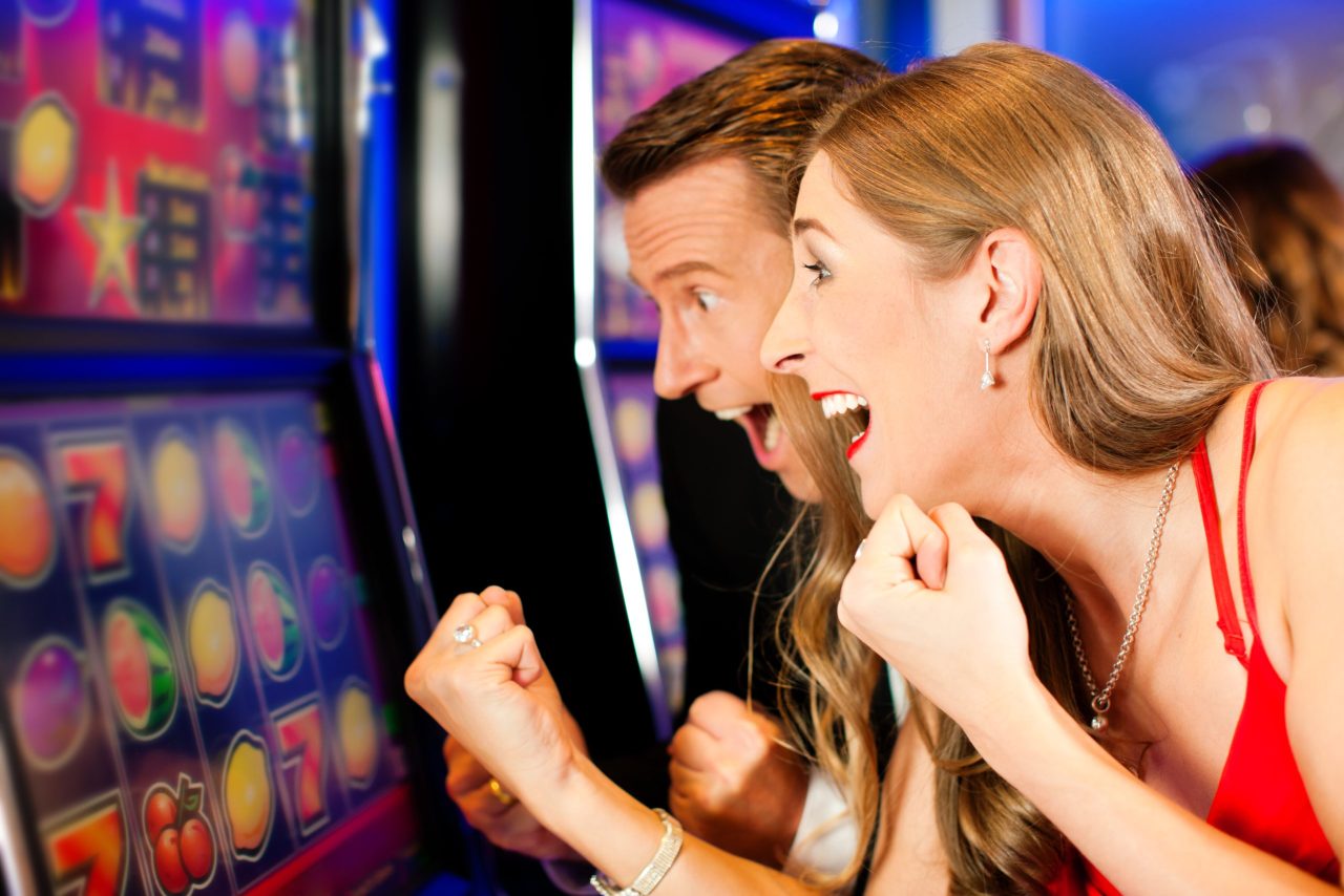 Couple in Casino on a slot machine